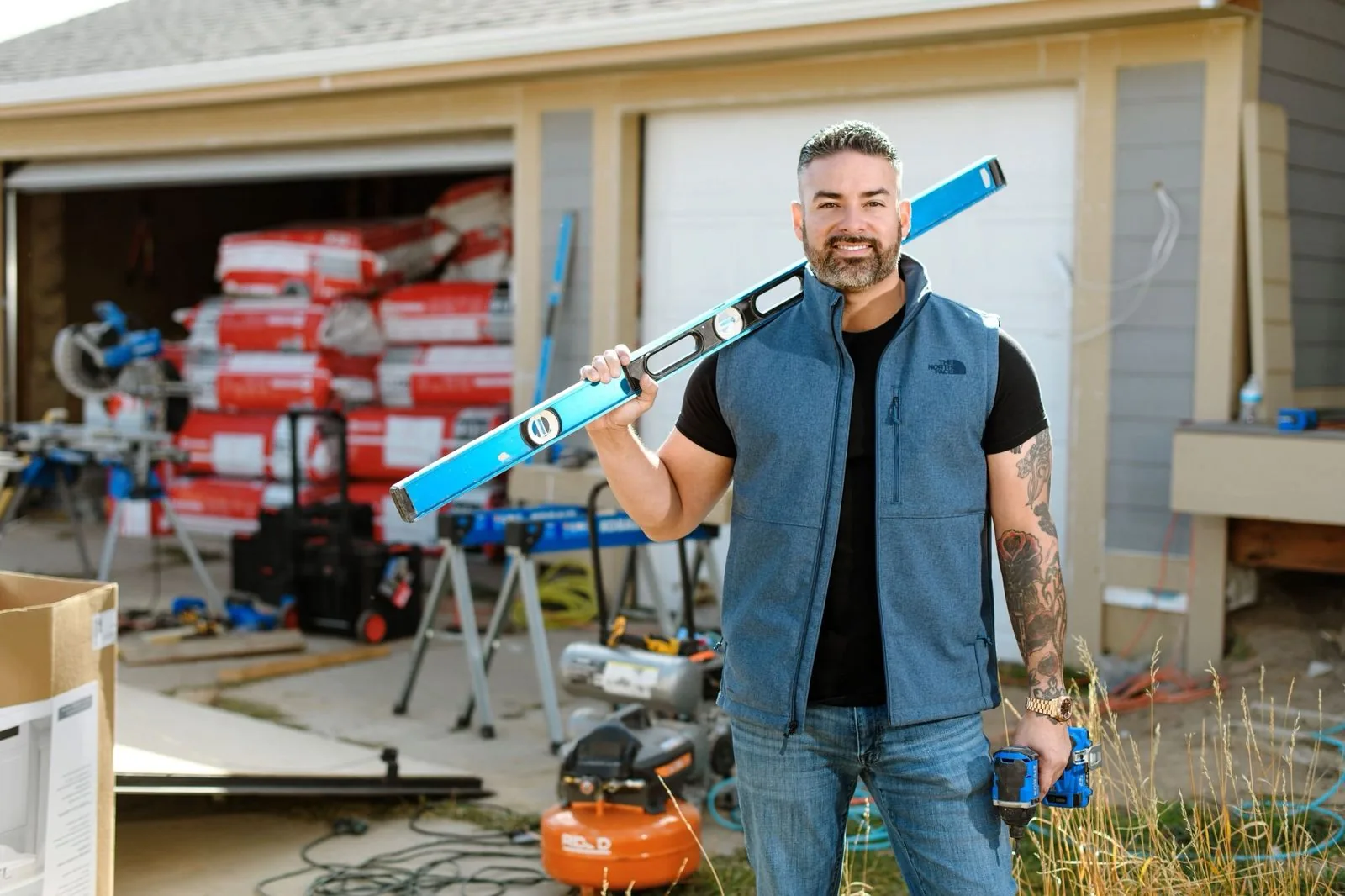 Rico Leon holding a level on a residential job site