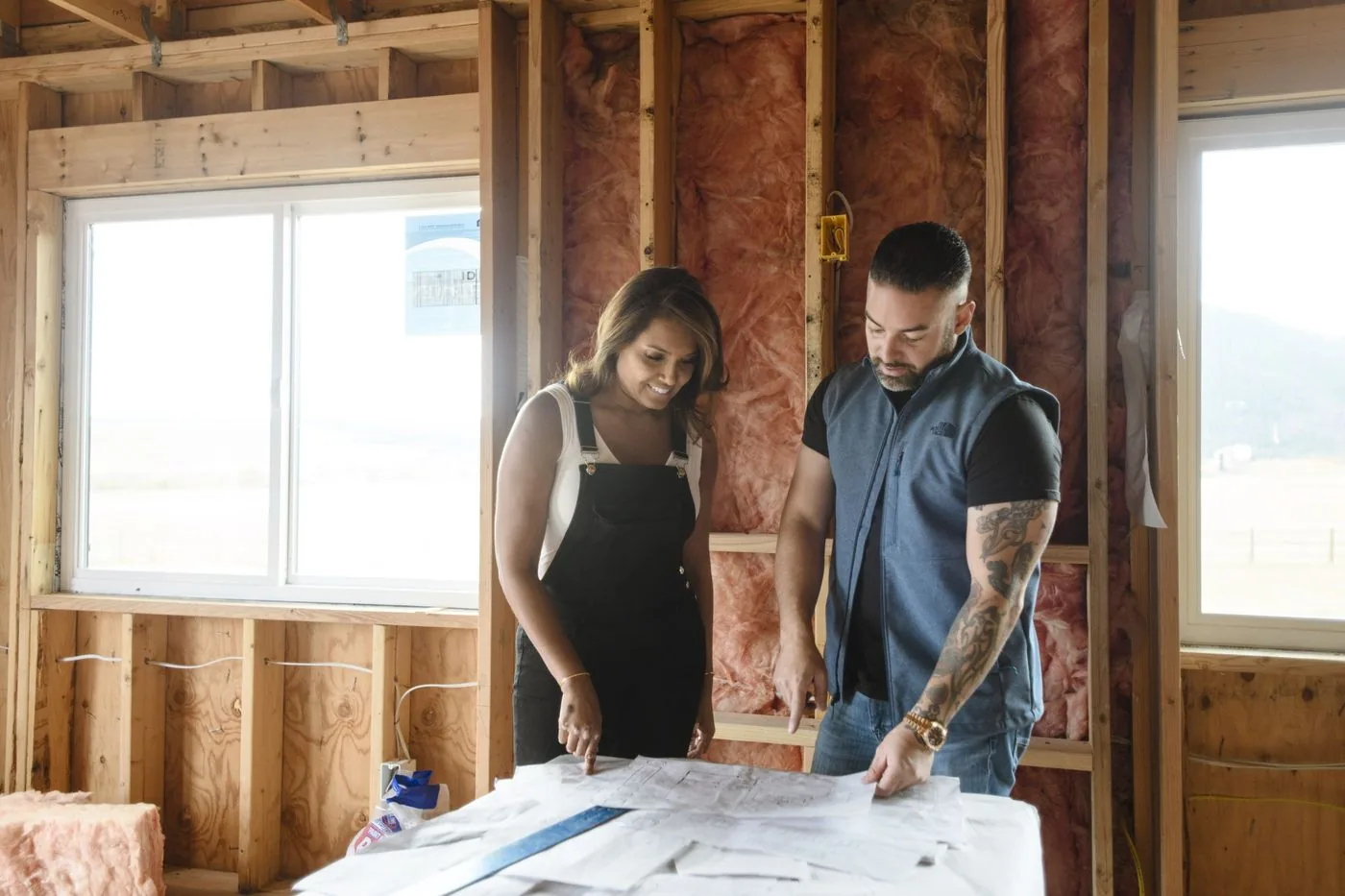 Rico Leon reviewing plans with a homeowner inside a stripped-down home